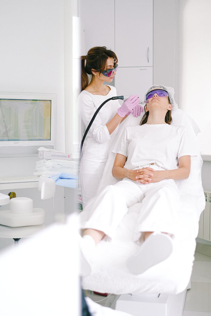 Two women in a clinic during a laser facial treatment, ensuring skincare and beauty.